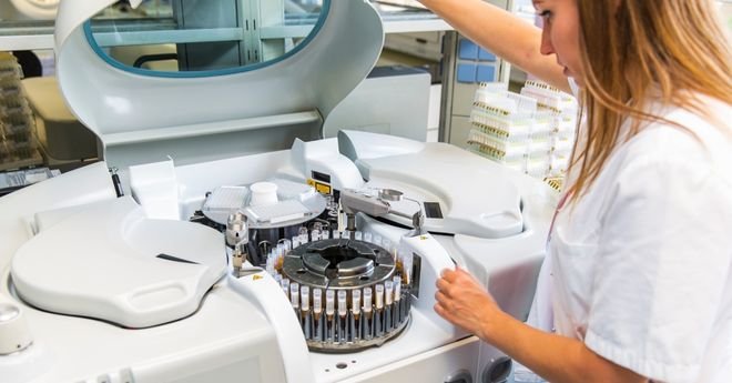 Female lab technician preparing centrifuge.&nbsp;